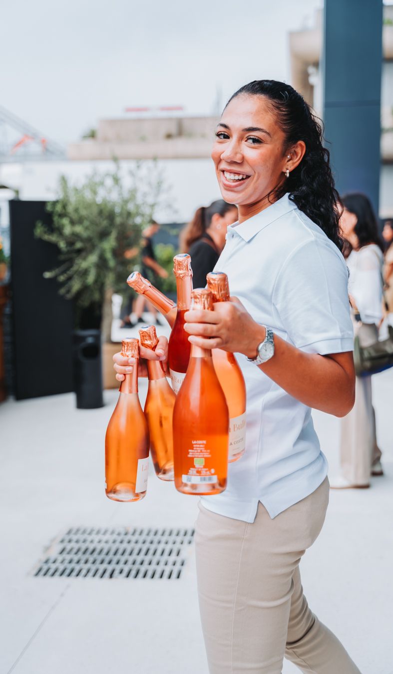 Jeune femme souriante servant des bouteilles de champagnes