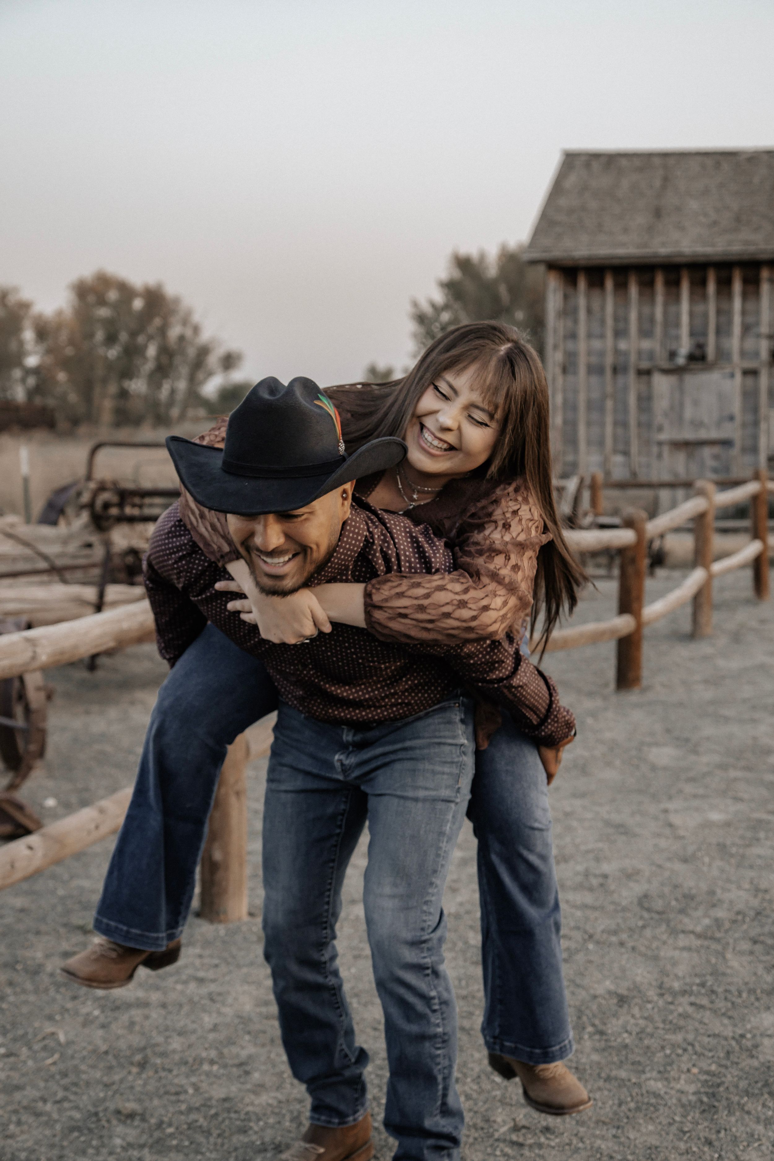 Man gives partner a piggyback ride while they are both laughing