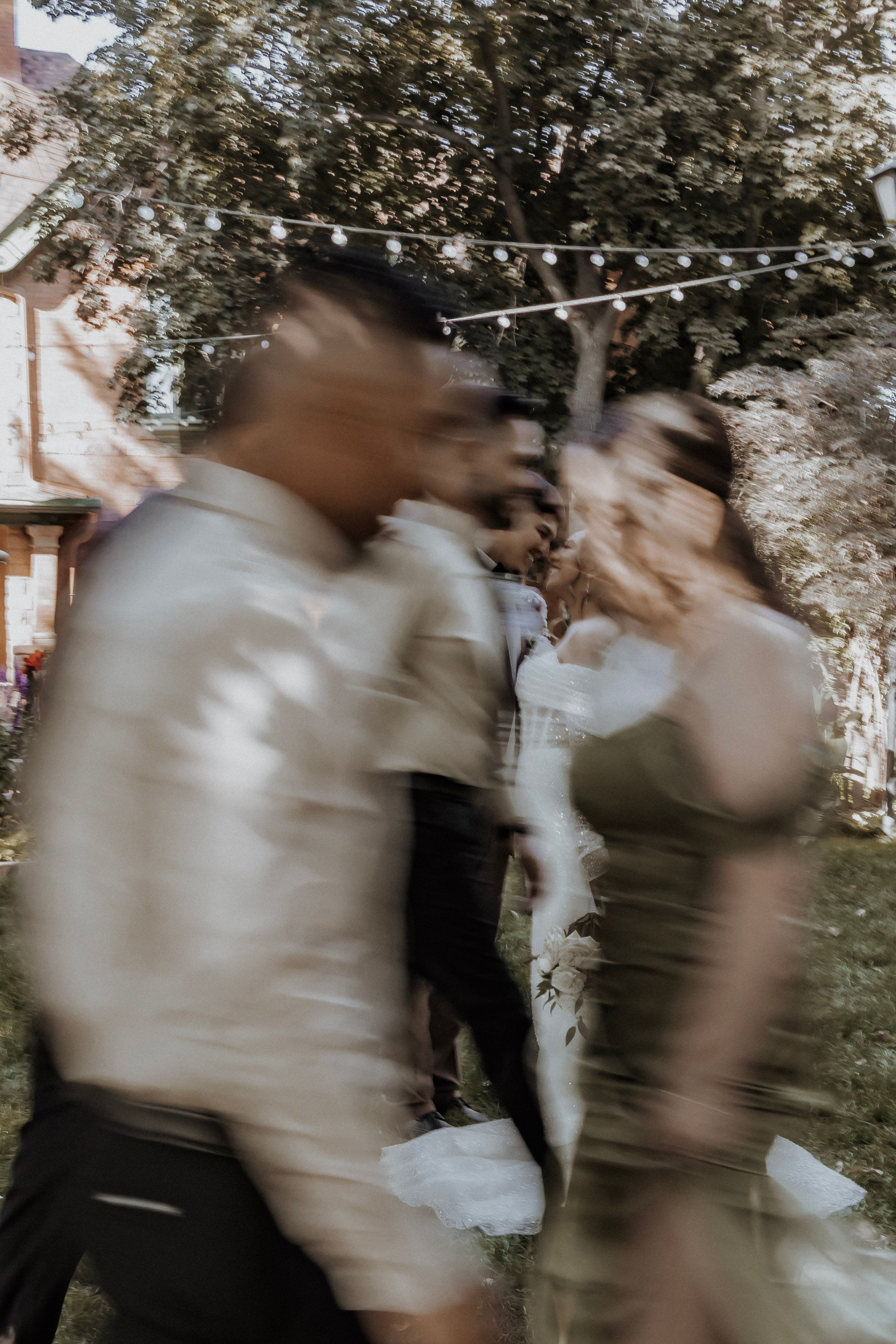 Bride and groom look at each other while wedding party moves around them