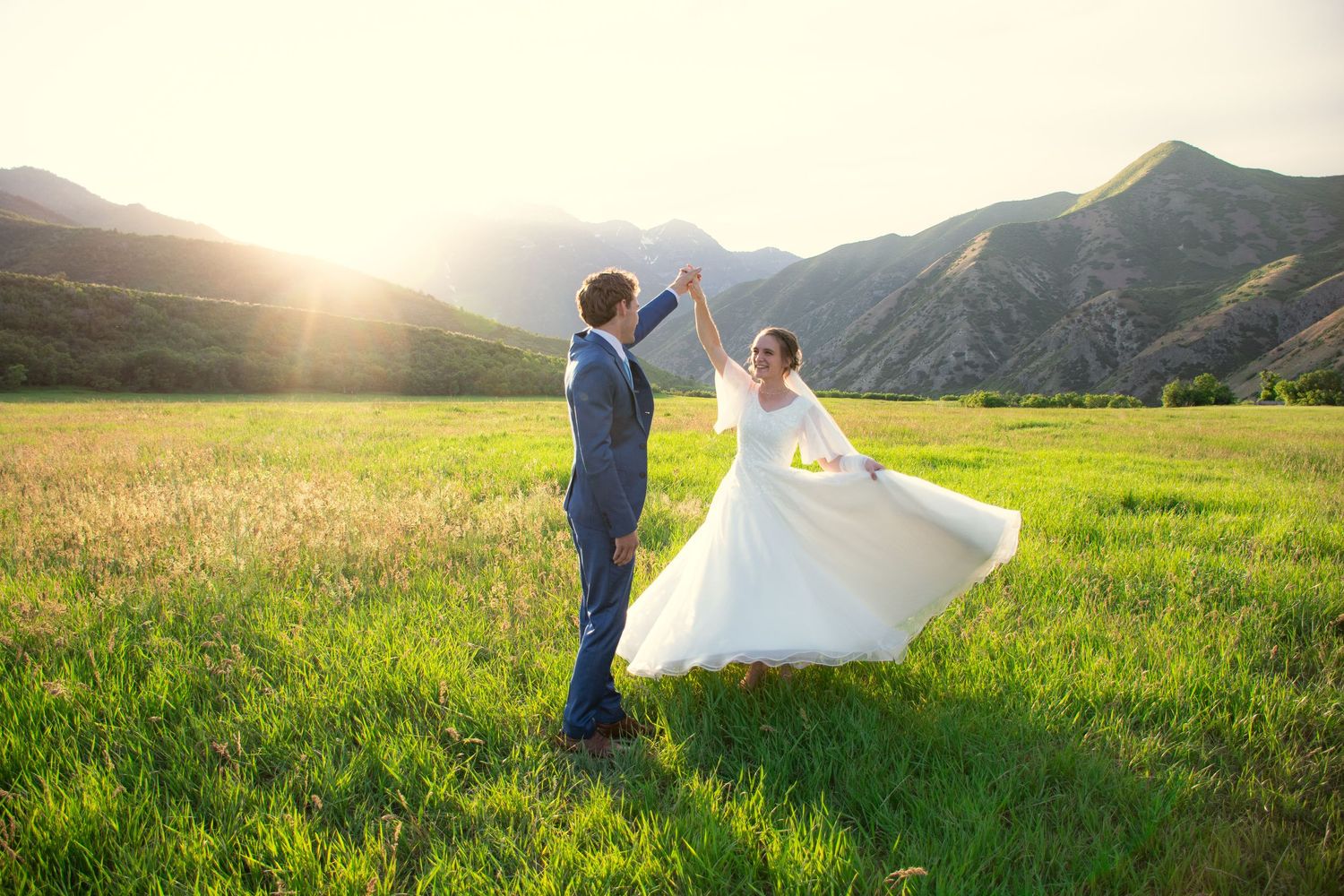 Bride and groom dancing in a cinematic photo against Utah mountains.
