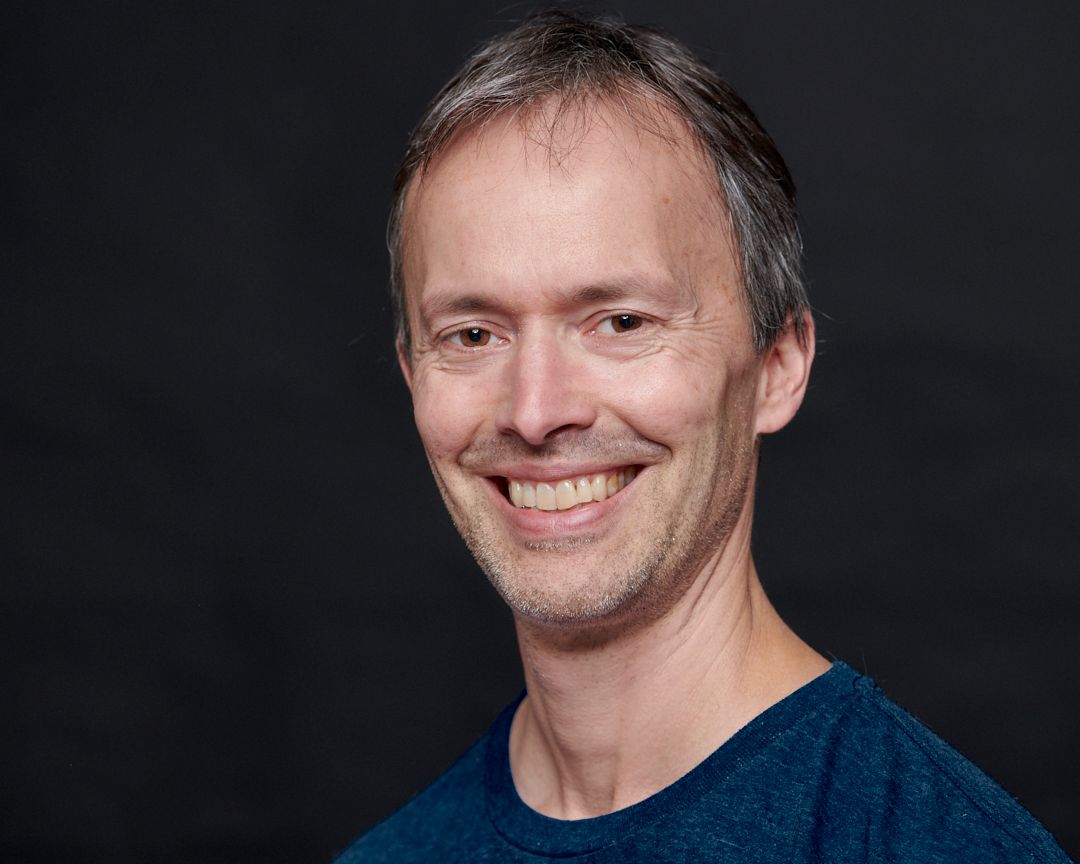 Headshot of Photographer Rob Pleas against black background.