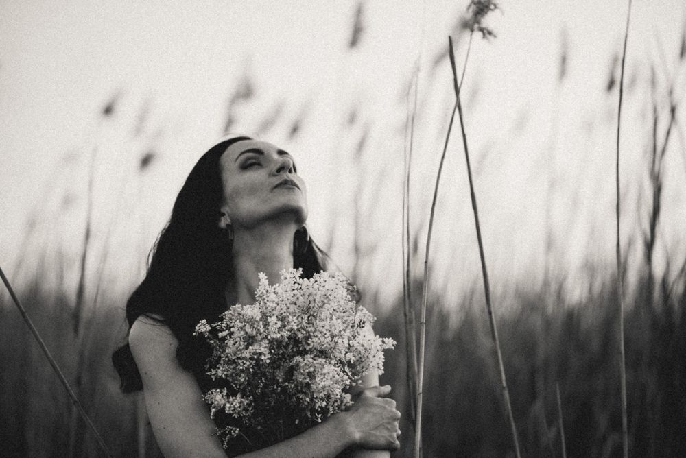 Black and white photos among tall grass and wildflowers in natural lighting.