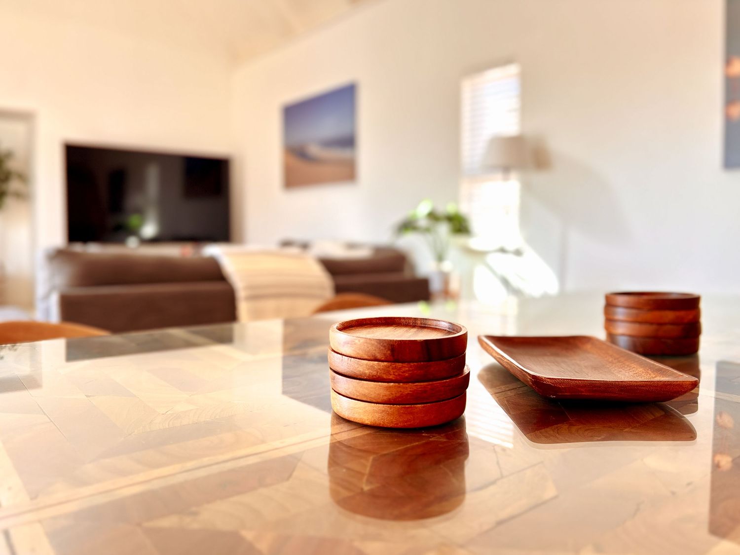 living area
Bright and airy lodge living room with neutral tones, fireplace, indoor plants and decorative wooden bowls on a coffee table