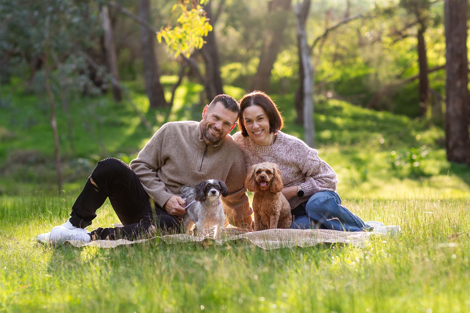 Couple sitting on a blanket with their two dogs during pet session in Perth