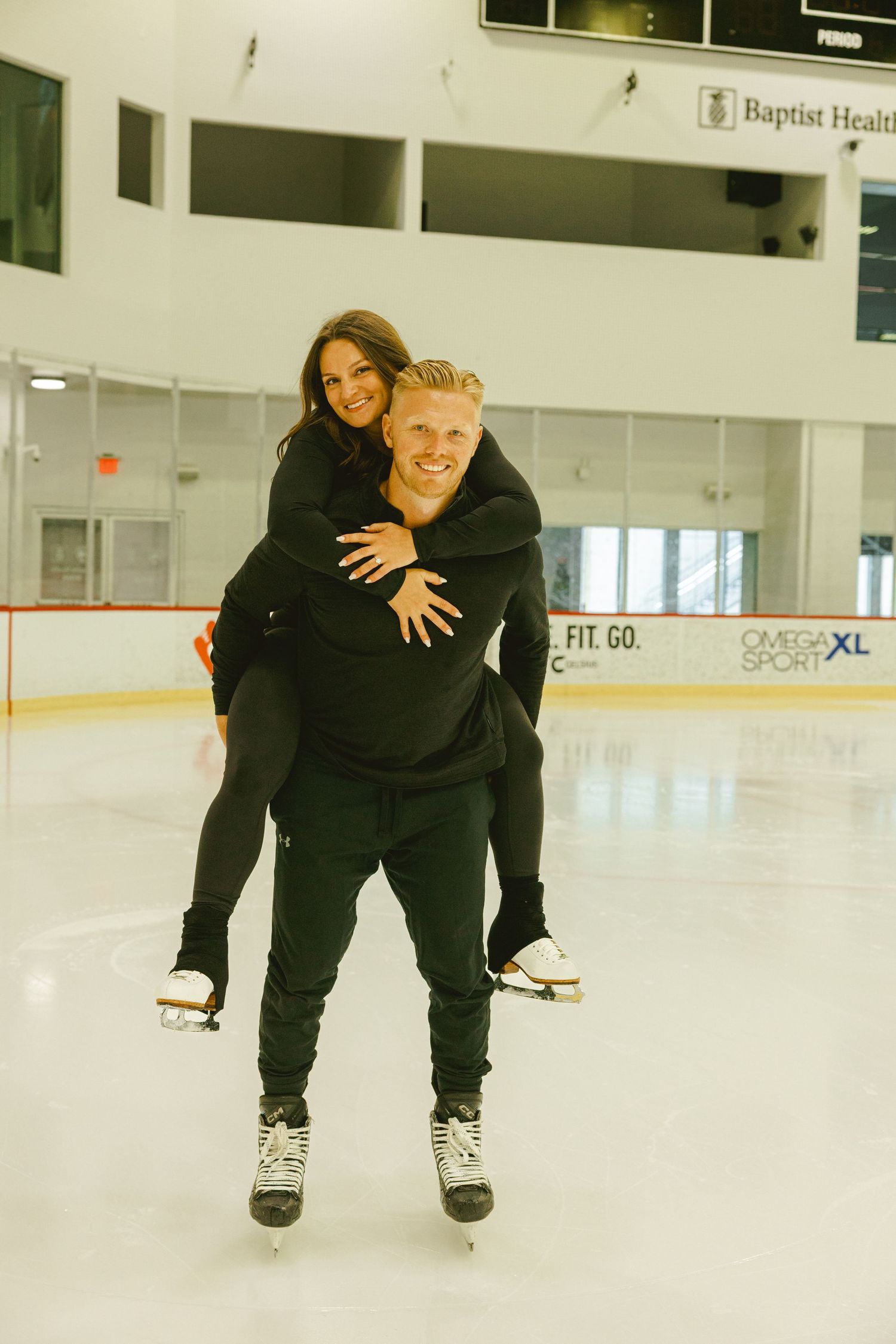 couple skating on ice doing piggy back ride for engagement shoot in fort lauderdale