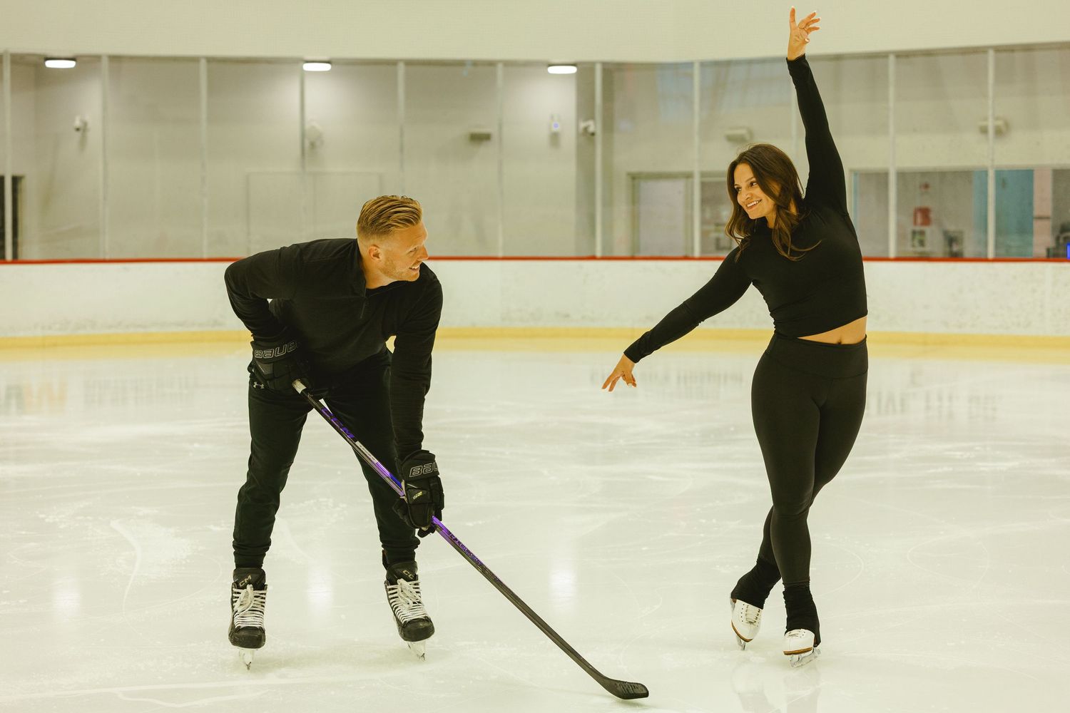 engaged couple posing for engagement photoshoot on ice rink