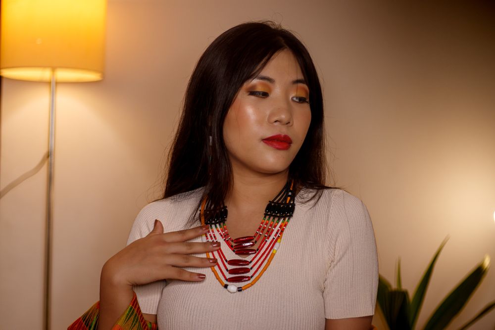 Woman wearing a multi-layered traditional beaded necklace and ethnic clothing.