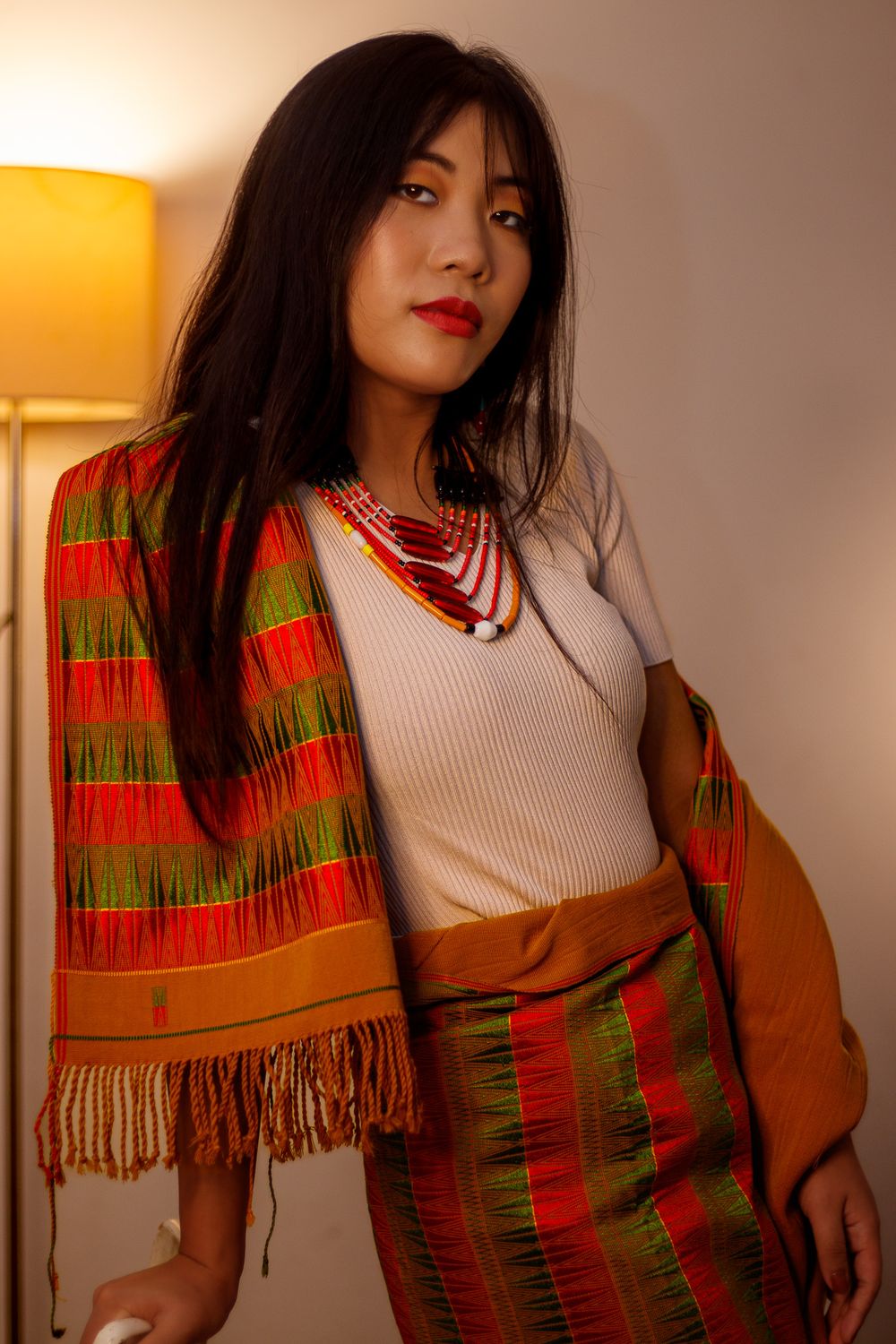 Full-length portrait of a woman in a traditional handloom [Mekhela Chador / Naga shawl / Ethnic] skirt and wrap.