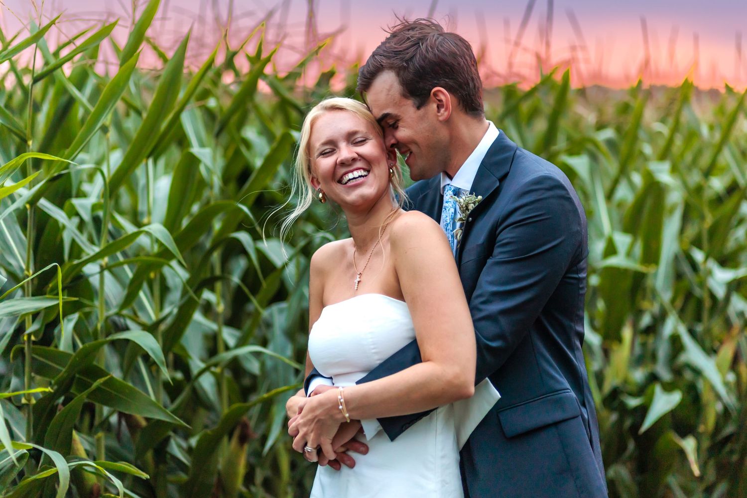 Couple sharing romantic moment by cornfield during sunset.