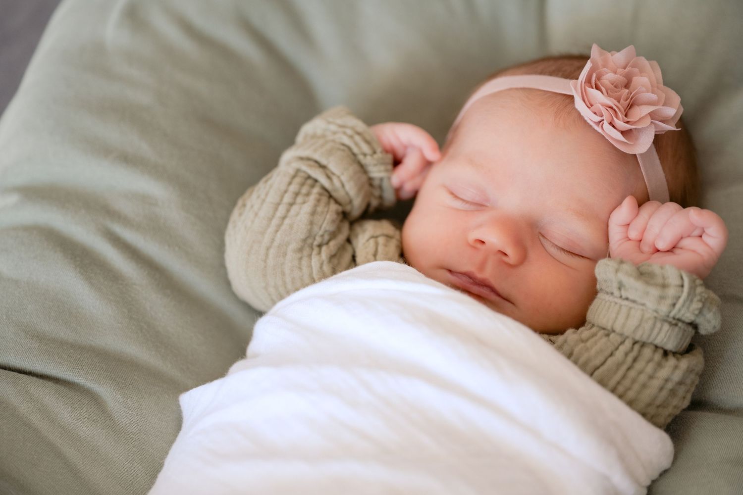 portrait of sleeping newborn with hands raised by head during in home lifestyle newborn session in lake elmo, mn