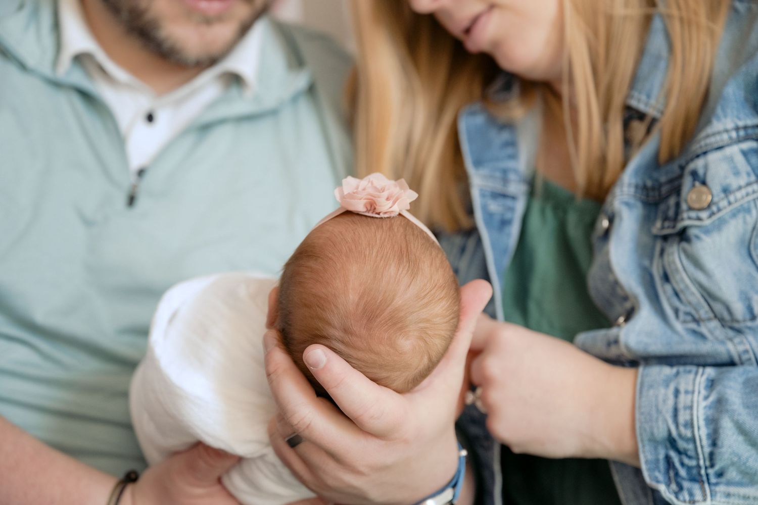 detail photo of baby's hair while parents gaze lovingly during in home lifestyle newborn session in lake elmo, mn
