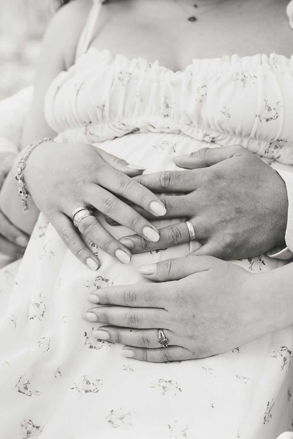 Black and white closeup shot of hands on pregnant belly