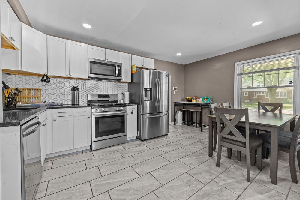 Updated kitchen with white cabinets stainless appliances and dining area in Dearborn Michigan