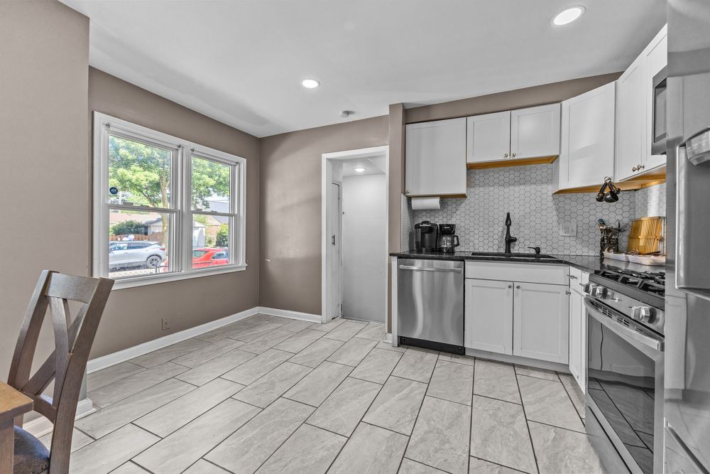 Updated kitchen with white cabinets stainless appliances and dining area in Dearborn Michigan