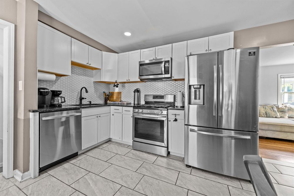 Updated kitchen with white cabinets stainless appliances and dining area in Dearborn Michigan