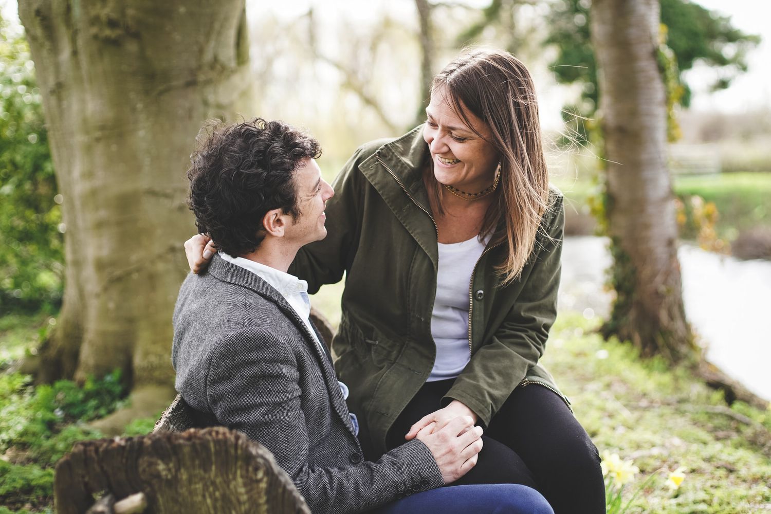 Couple sharing a romantic moment between grand white columns at an elegant outdoor venue.