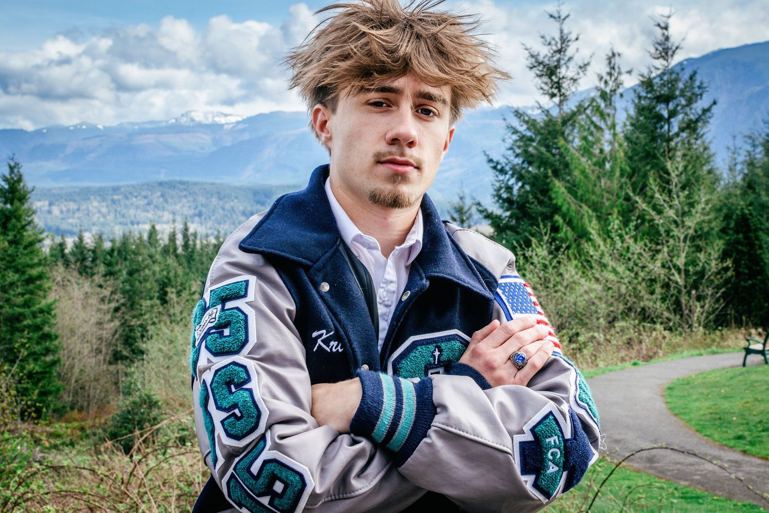 Male senior portrait with football letterman jacket during Washington mountain graduation session an hour from Seattle at Snoqualmie Point.