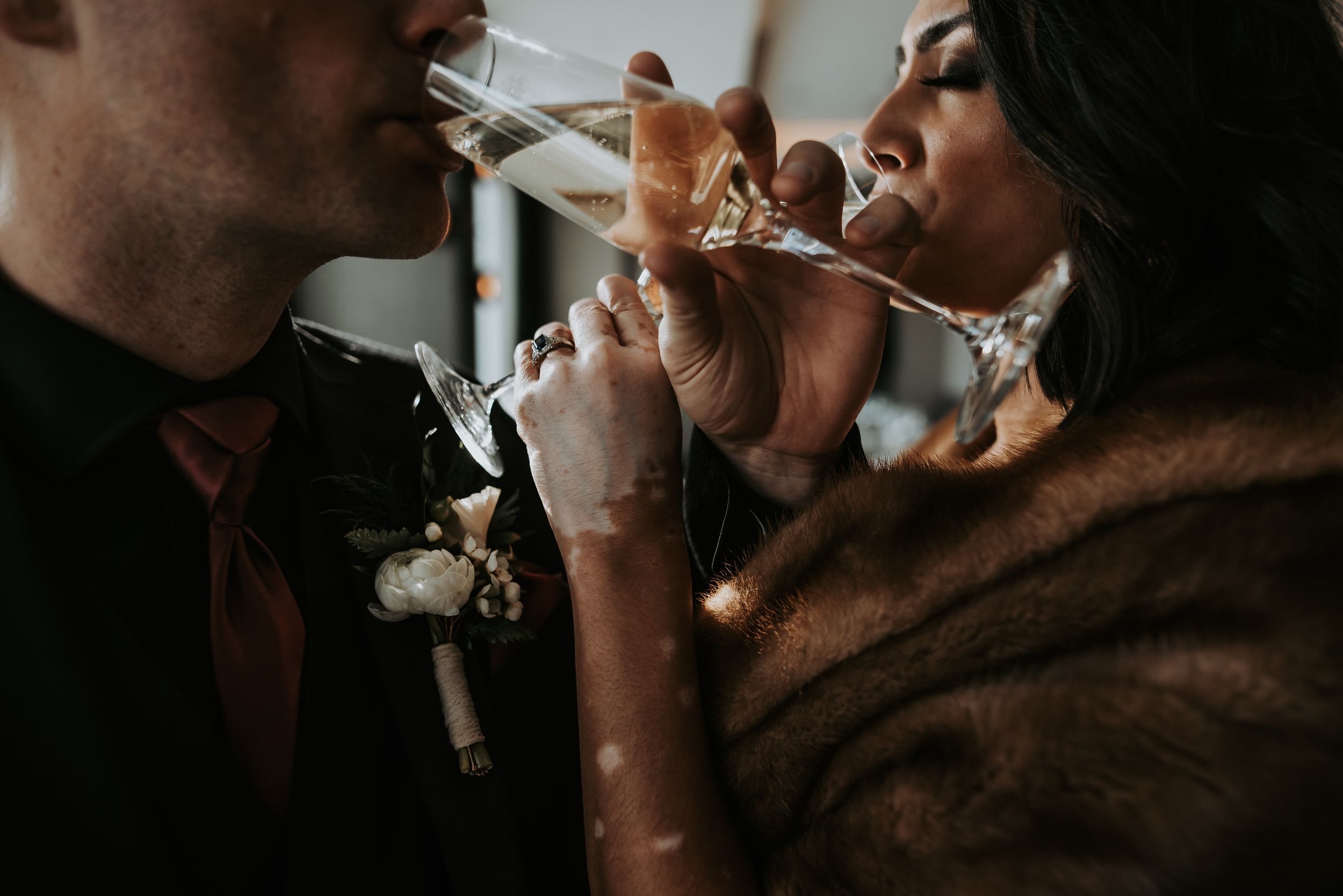 Bride and groom share an intimate champagne toast in a close romantic moment at their wedding.