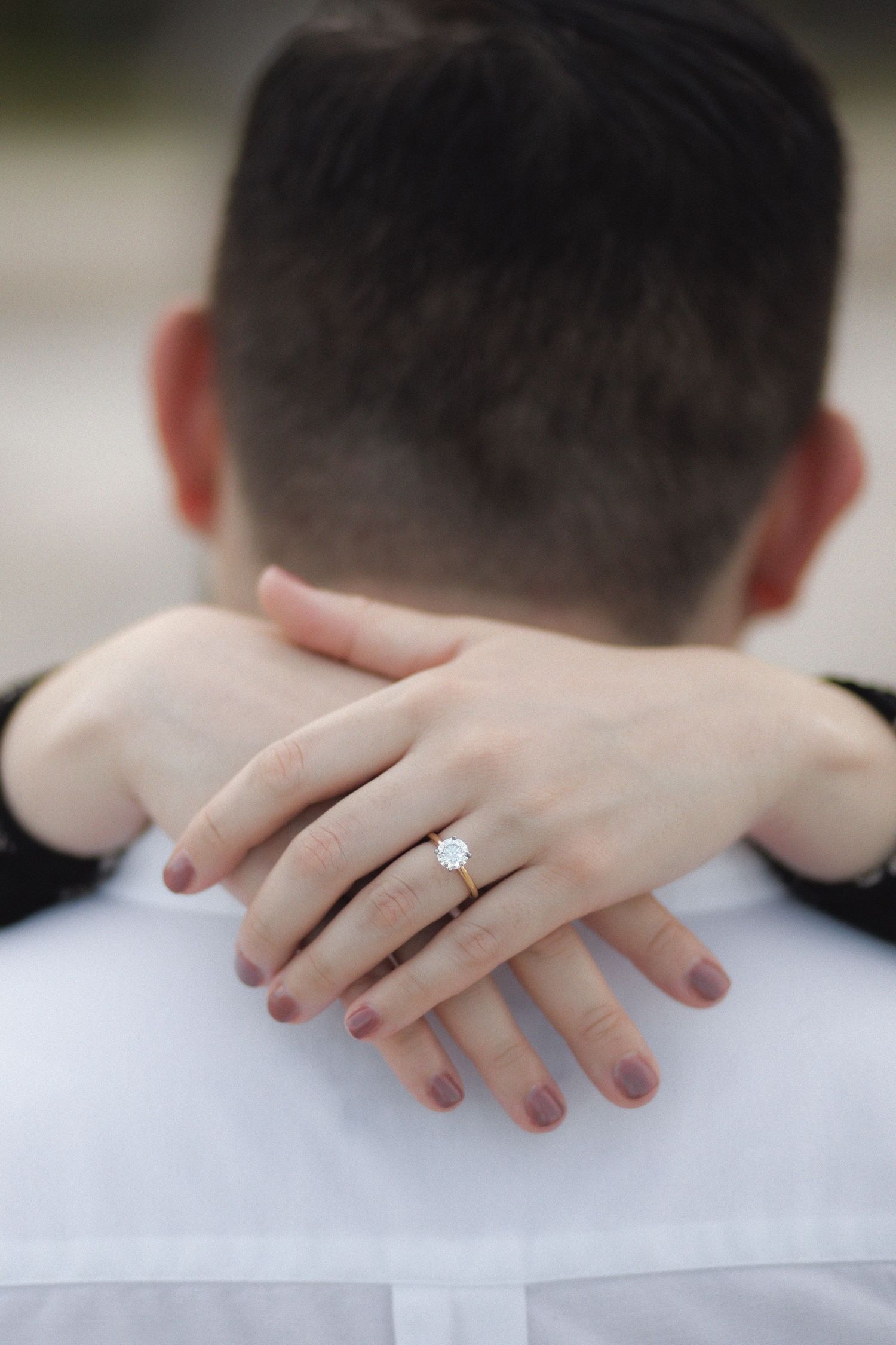 Womans hand showcasing ring in Crandon Park during engagement couples session.