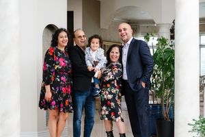 A family of 5 smiling at the camera