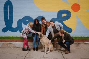 A family of 5 petting their dog