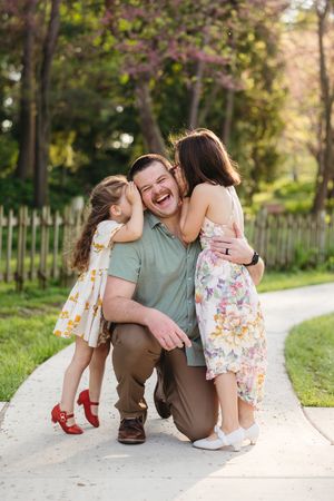 A father is told a secret by both of his daughters in each ear