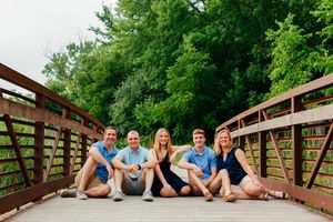 Photo of a family sitting on a bridge
