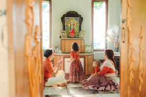A family sits on the floor of a temple, offering prayer