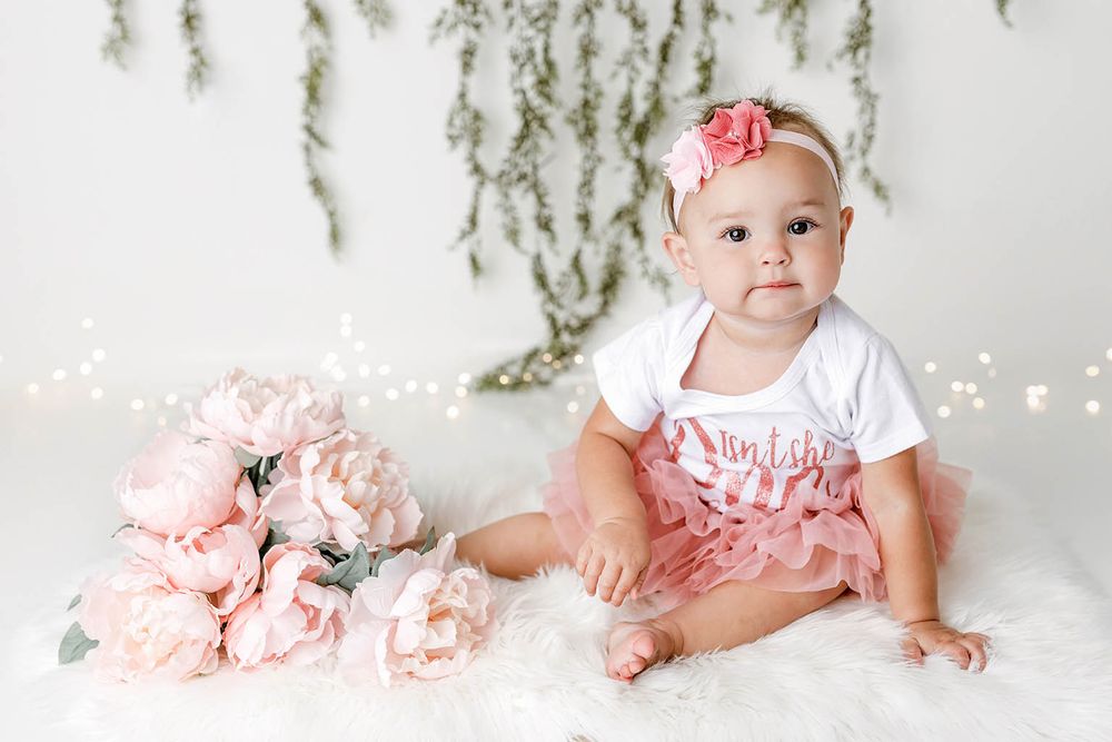 Baby girl in pink tutu and floral headband by Temescal Valley cake smash photographer.