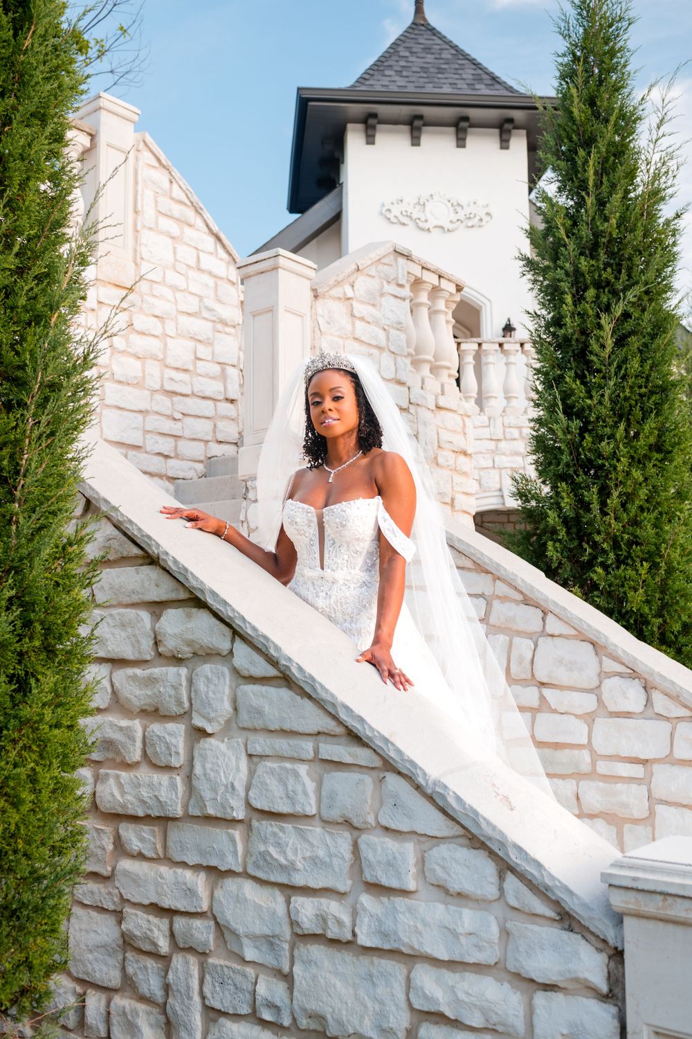 Elegant white stone staircase with evergreen trees creates a romantic architectural backdrop.