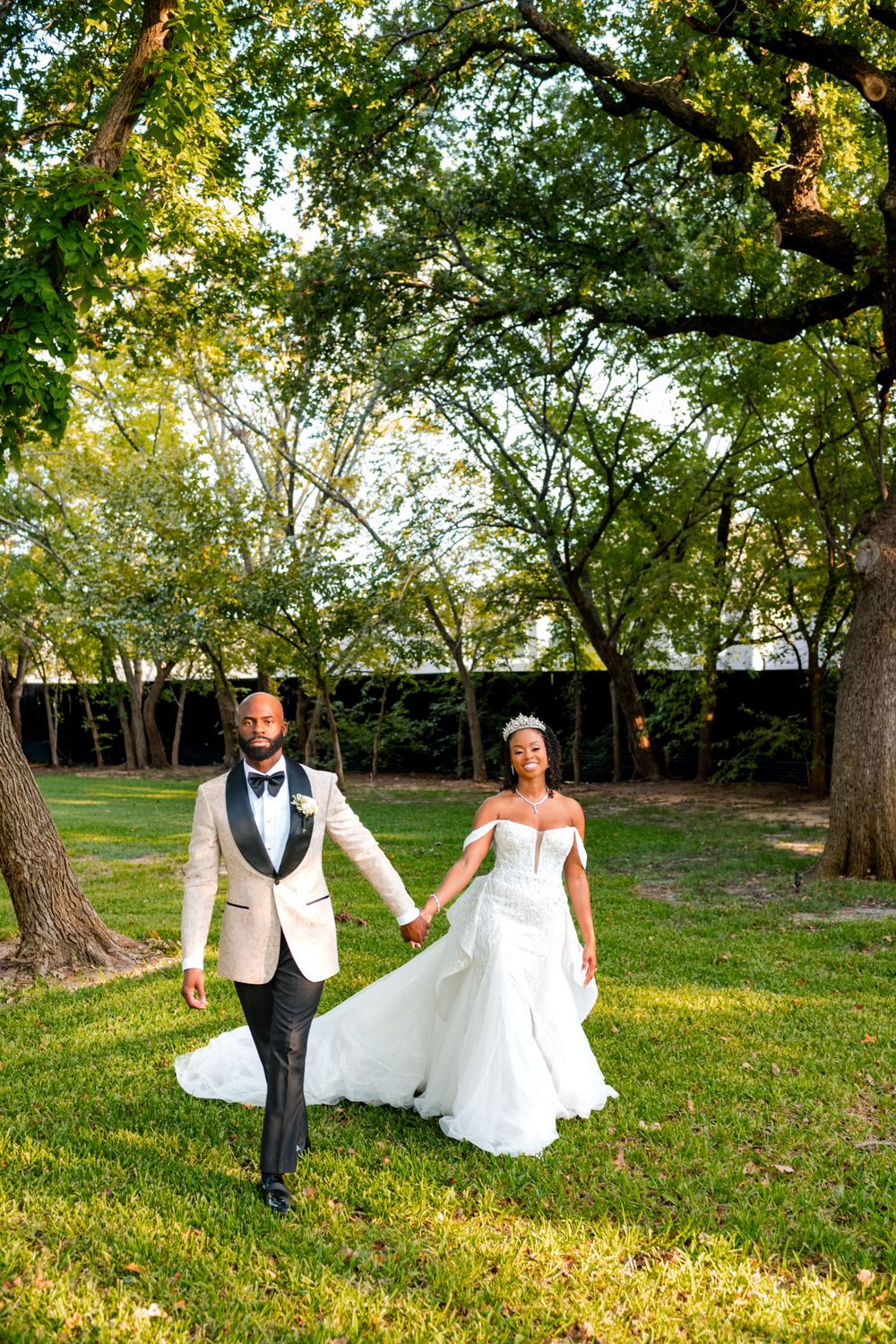 A romantic wedding photo series showing a couple walking through a sunlit park with lush green trees.