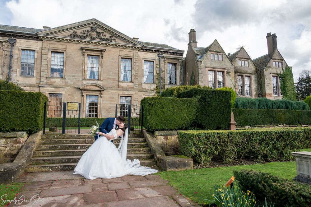 SimplyGreatShots couple portraits of Mark and Minky kissing on a stone pathway in Coombe Abbey's ornate gardens.