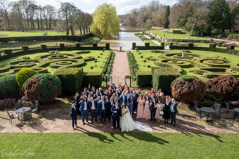 SimplyGreatShots capturing a large wedding group photo of guests raising glasses on the Coombe Abbey terrace.