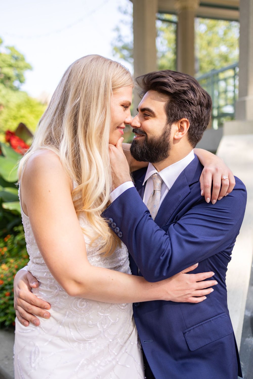 Bride and groom embrace and smile at each other outdoors, wearing wedding attire with greenery in the background. Cincinnati Elopement Photo