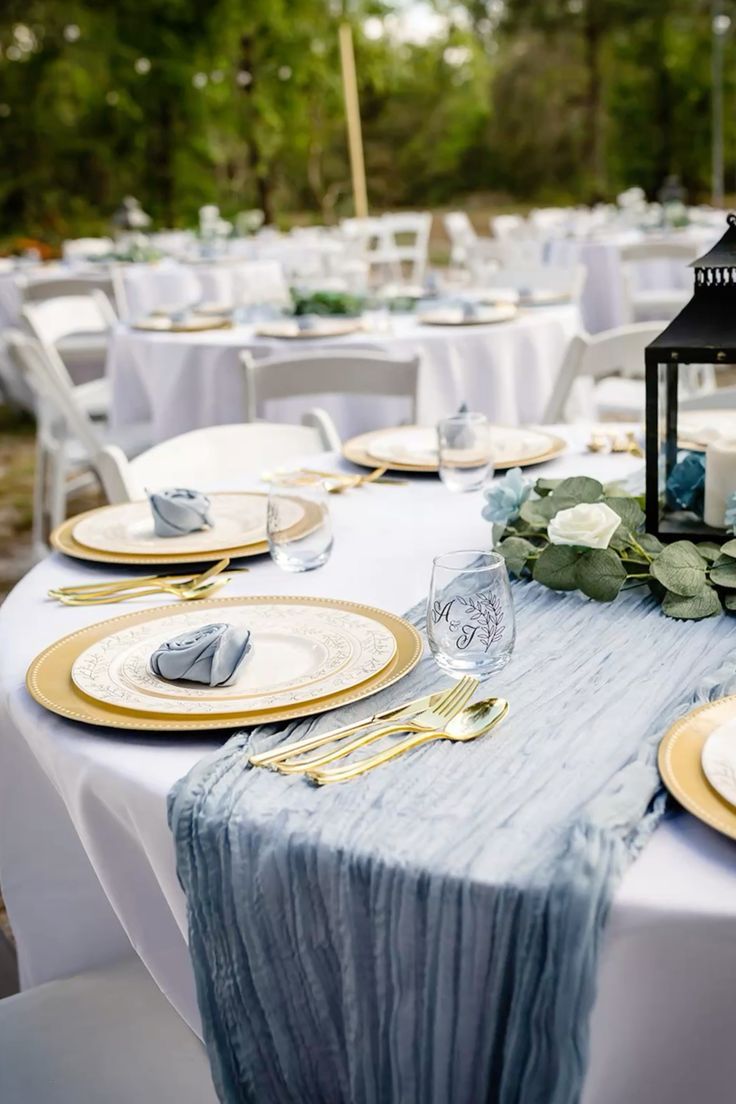 Coastal blue gauze runner and gold charger plates for a cool and intimate celebration vibe