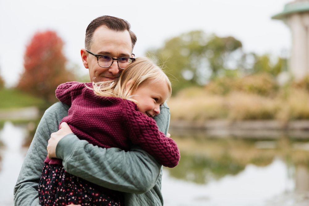 Couple sharing an intimate embrace outdoors on an autumn day.