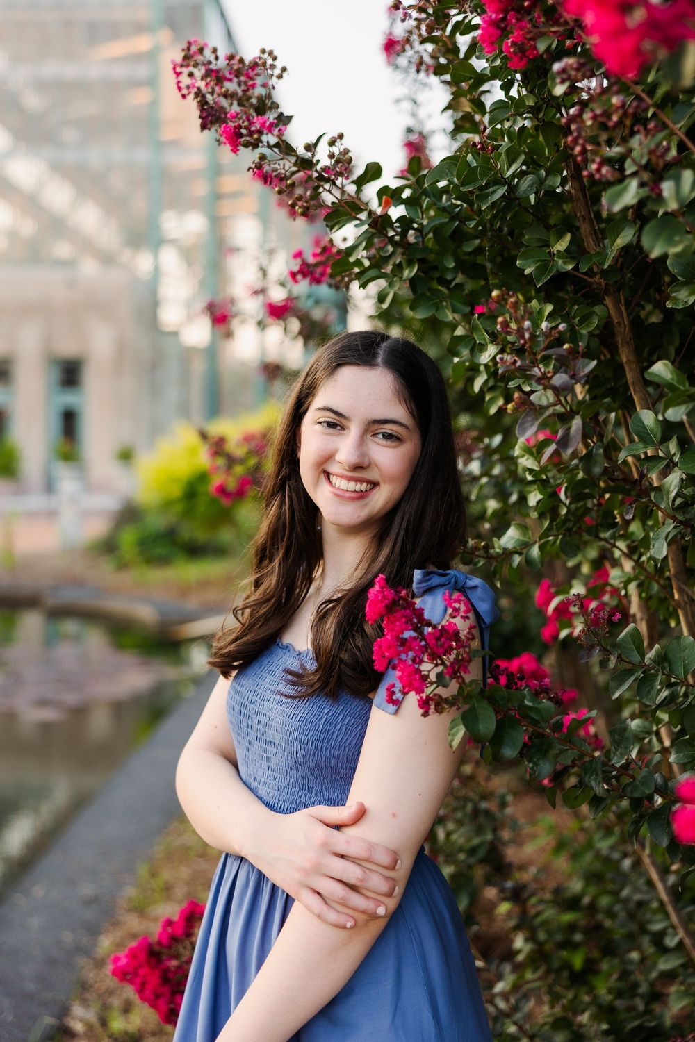 Portrait against vibrant pink bougainvillea flowers with person in blue dress.