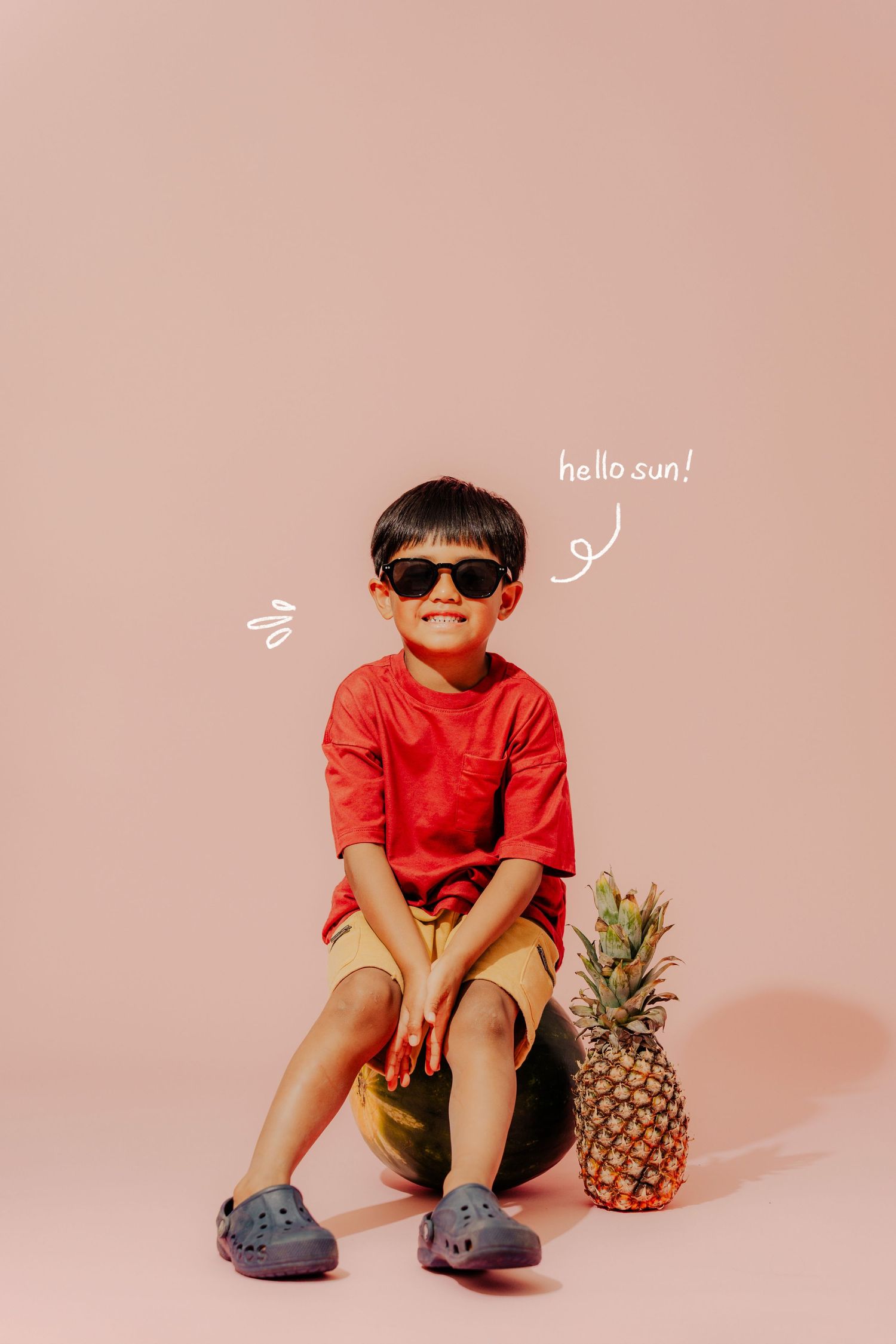 Playful photo series with pineapple and child in red shirt against pink background.