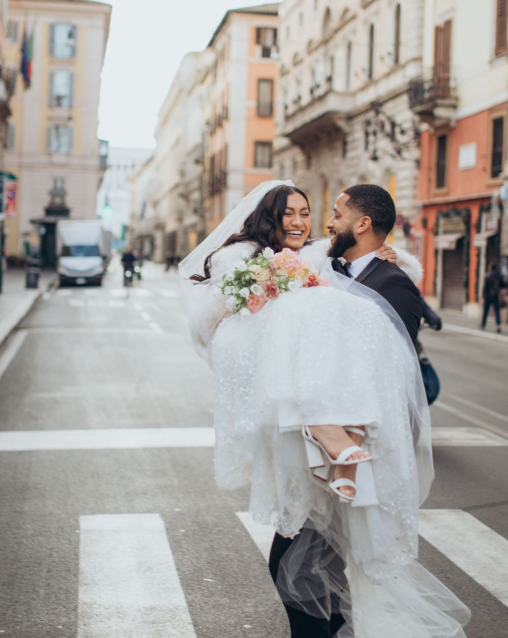 Wedding couple sharing a joyful moment on an Italian street as they celebrate their special day.