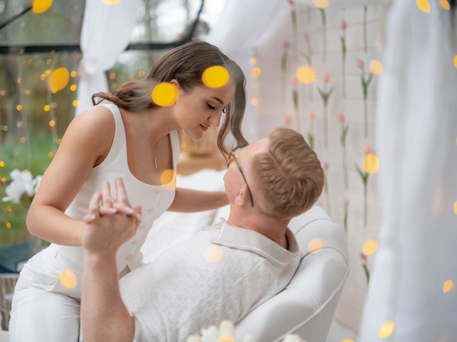 A romantic dance moment with yellow tulips and white fabric draping in the background.