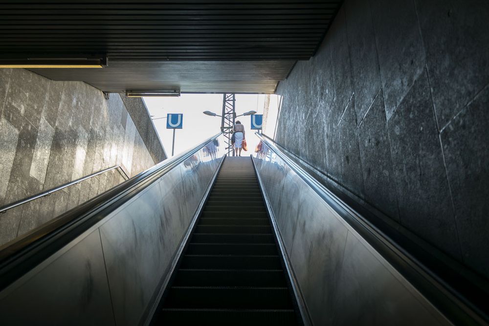 Solitude.Woman alone in the infrastructure of the city. Elevator System at Cologne Deutz Bahnhof.
