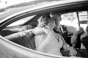Bride and groom share a romantic kiss inside a vintage car in this black and white wedding photo in Palmerston, Ontario.