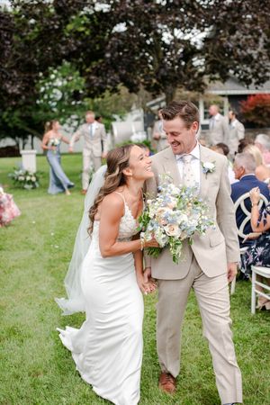 Radiant bride and groom walk back down the aisle laughing together after their outdoor garden wedding ceremony in Woodstock.