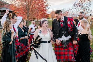Joyful wedding party in red tartan kilts and black gowns celebrate outdoors in autumn setting, In Brussels Ontario.