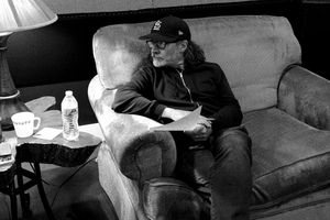 Person resting on couch in recording studio lounge area.