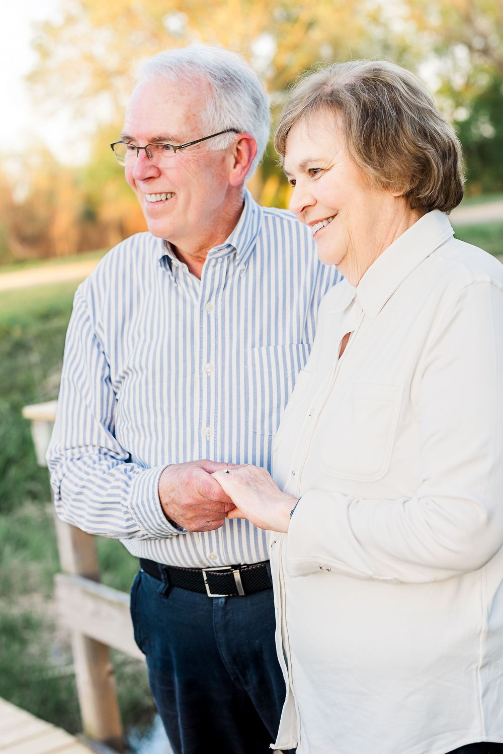 Happy senior couple enjoying a warm autumn day outdoors while sharing a laugh together.