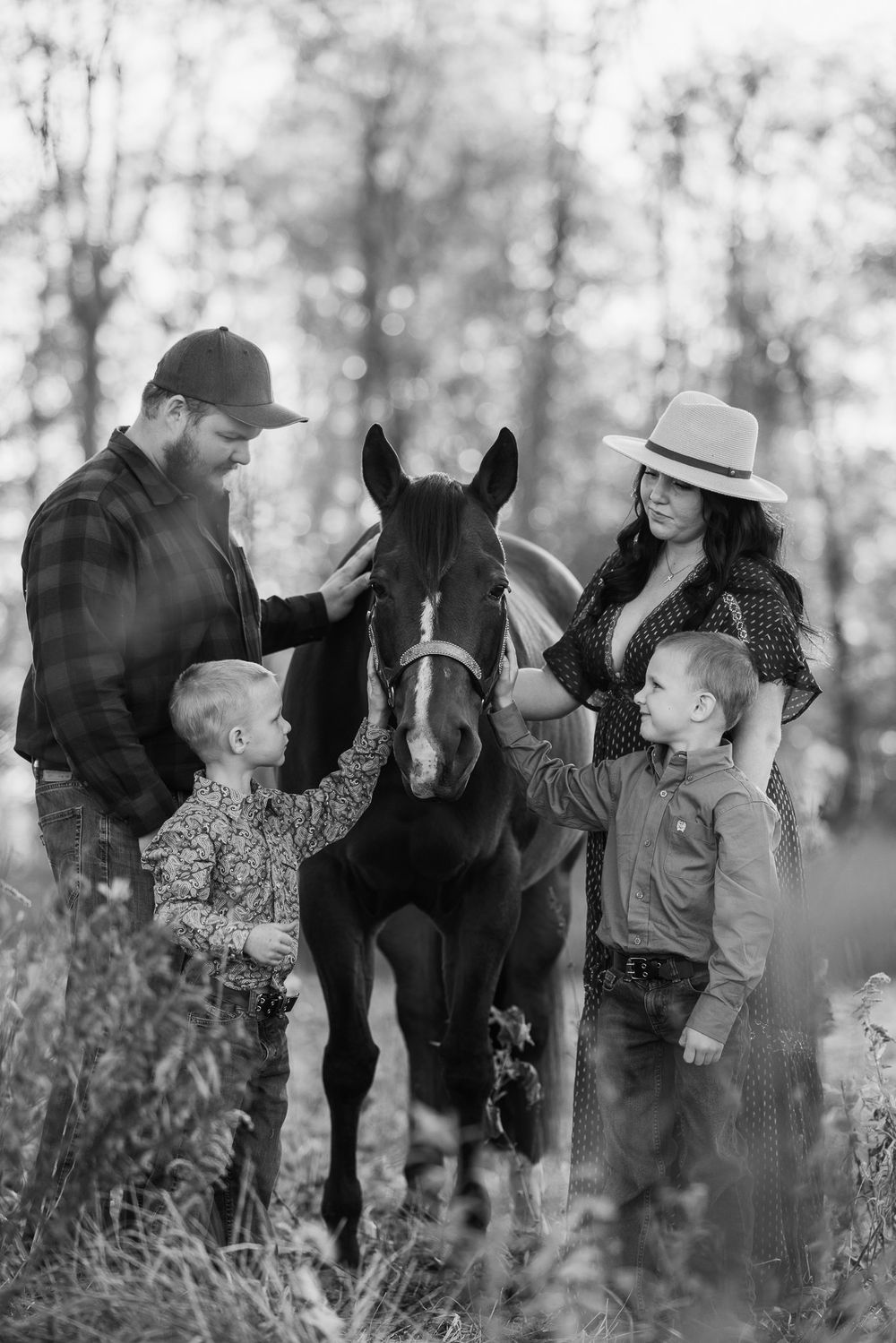 A family gathers around their horse in a peaceful woodland setting during autumn.