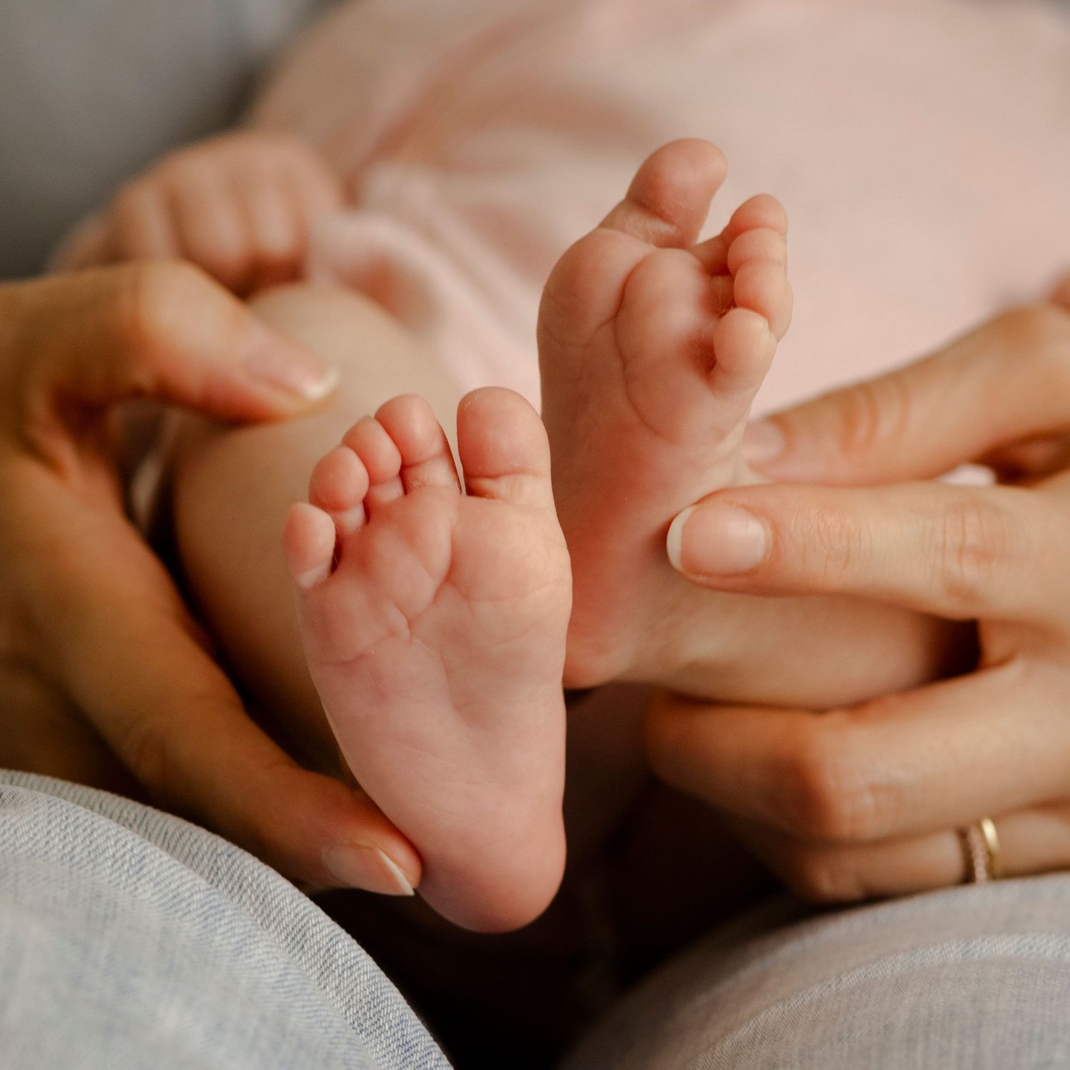 Détail des pieds de bébé pendant une séance photo naissance