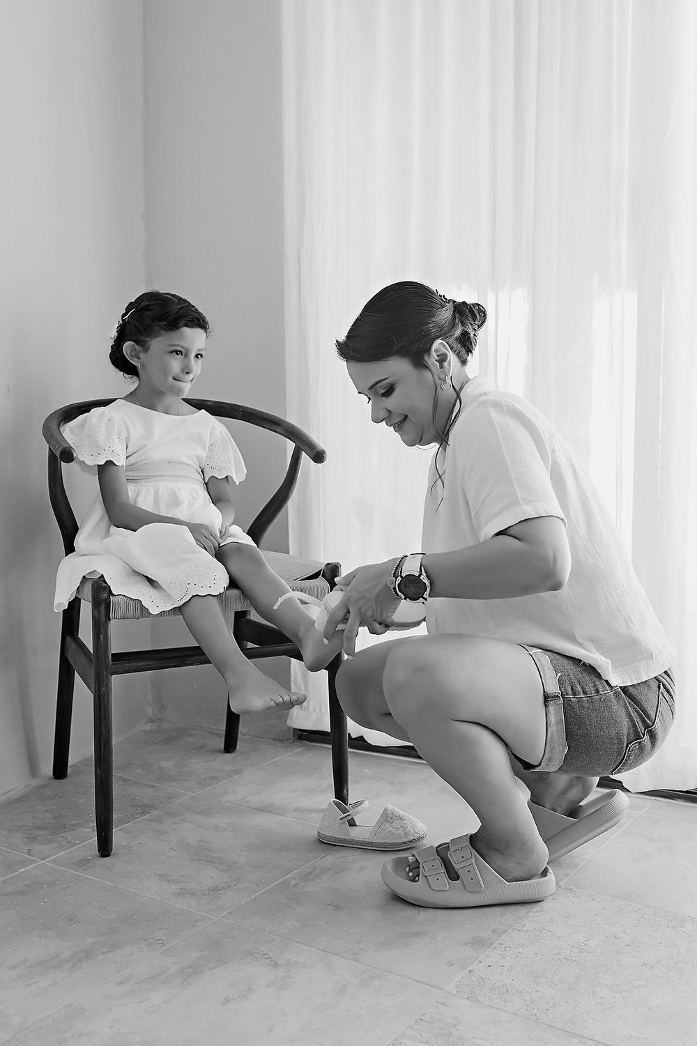 A medical professional in white attends to a young patient sitting in a chair during a pediatric checkup.