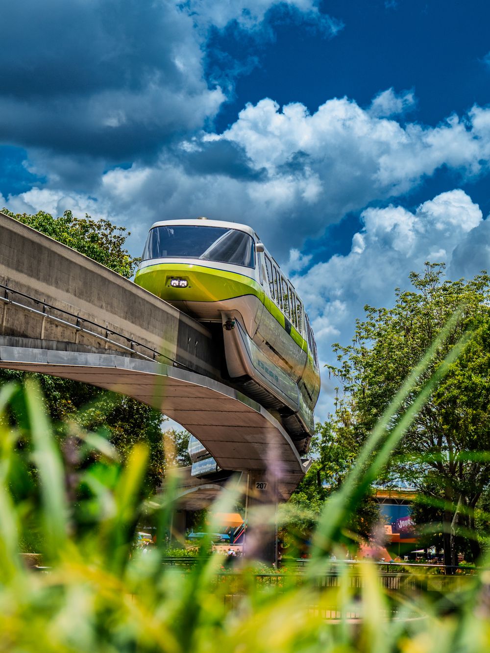 Low angle view of monorail track with lush green grass in foreground at Disney World.